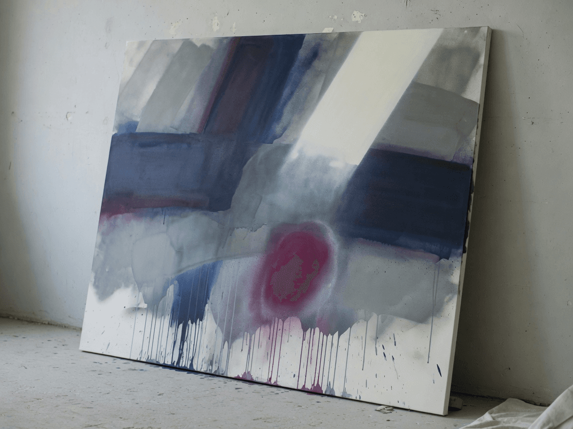 A large finished abstract spray painting leaning against a studio wall