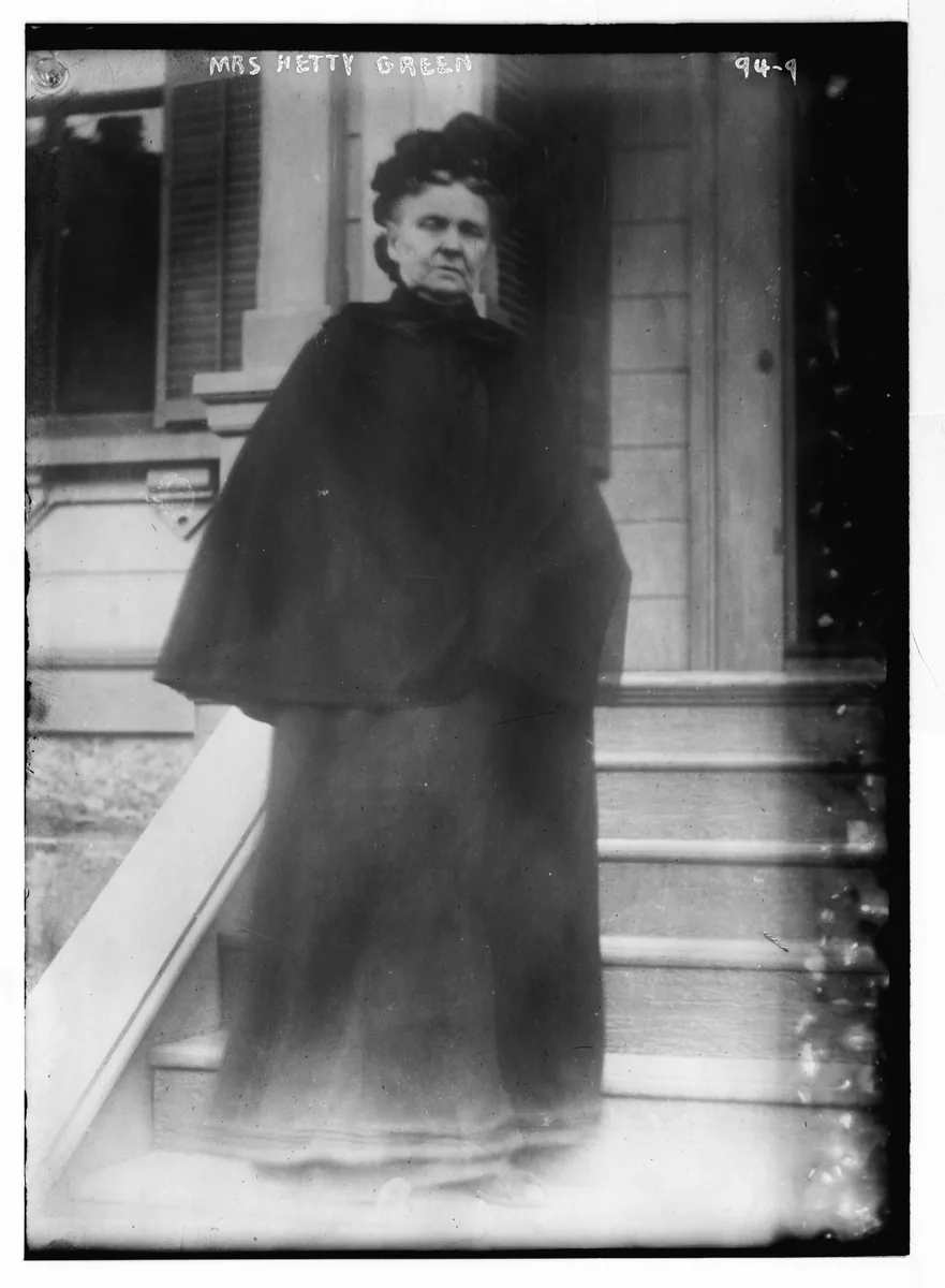 A glass negative from the George Grantham Bain Collection shows the subject standing on a porch staircase in outdoor dress, labeled Mrs. Hetty Green on the plate itself.
